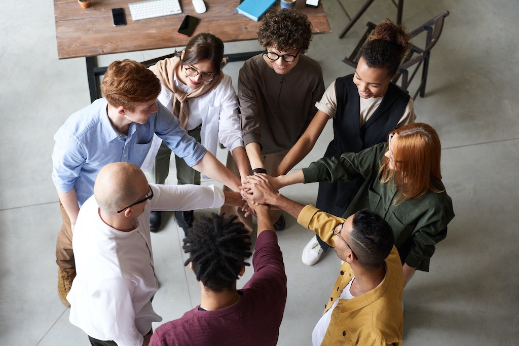 group of people with hands together in a huddle
